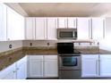 Modern kitchen featuring granite countertops, stainless steel appliances, and white cabinetry at 1704 E Redfield Rd, Gilbert, AZ 85234
