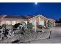 Charming home featuring a tiled roof, solar panels, and desert landscaping at night at 17211 N 58Th St, Scottsdale, AZ 85254