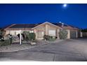 Charming home featuring a tiled roof, solar panels, long driveway, and desert landscaping at night at 17211 N 58Th St, Scottsdale, AZ 85254