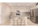 Well-appointed kitchen with stainless steel appliances, granite countertops, and island seating at 17320 W Daley Ln, Surprise, AZ 85387