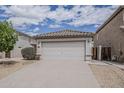 Charming home featuring a two-car garage, desert landscaping, and a manicured garden bed at 1744 W Brookwood Ct, Phoenix, AZ 85045