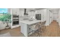 Modern kitchen with white cabinets, stainless steel appliances, quartz countertops, and center island with seating at 1876 S Huish Dr, Gilbert, AZ 85295