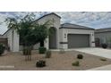 Charming single-story home featuring a two-car garage and desert landscaping at 30395 W Mitchell Ave, Buckeye, AZ 85396