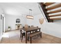 Dining room with modern table and bench seating, complemented by stylish lighting, and staircase with open design at 309 E Huntington Dr, Tempe, AZ 85282