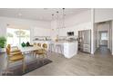 Bright, open kitchen and dining area features white cabinets, island with bar seating, and stainless steel appliances at 32017 N Redding St, Wittmann, AZ 85361