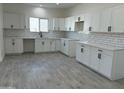 Bright kitchen featuring white cabinets, sleek black hardware, subway tile backsplash, and tile flooring at 4116 E Park St, Phoenix, AZ 85042