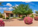 View of the landscaped front yard featuring lush greenery, desert landscaping, and a well-maintained exterior at 4232 W Purdue Ave, Phoenix, AZ 85051
