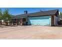 Single story home featuring covered porch with front seating and a light blue garage door at 4402 N 79Th Dr, Phoenix, AZ 85033