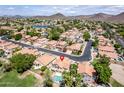 Scenic aerial shot of a neighborhood featuring houses with tiled roofs, a serene lake, and green landscapes, creating a peaceful setting at 5953 W Aurora Dr, Glendale, AZ 85308