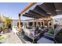 Inviting backyard with multiple seating areas, mature landscaping, and a pergola for shade at 6314 N 14Th St, Phoenix, AZ 85014