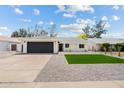 Charming single-story home with manicured lawn, dark garage door, and gravel landscaping at 6351 E Waltann Ln, Scottsdale, AZ 85254