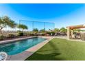 Inviting backyard oasis with a refreshing pool, lush turf, and cozy patio seating area at 766 E Taylor Trl, San Tan Valley, AZ 85143