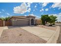 Home exterior featuring a well-maintained yard, long driveway, and neutral stucco at 81 E Rock Wren Dr, San Tan Valley, AZ 85143