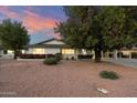 Charming single-story house with mature trees, colorful flower beds, and a long driveway at 8228 E Oak St, Scottsdale, AZ 85257