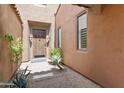 Inviting entryway featuring a solid wood door, stylish sconces, and desert landscaping at 8512 E Gilded Perch Dr, Scottsdale, AZ 85255
