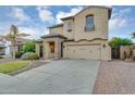 Inviting two-story home boasts desert landscaping, a spacious driveway, and an attached garage at 880 E Wimpole Ave, Gilbert, AZ 85297
