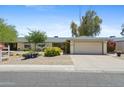 Charming single-story home featuring a well-maintained front yard with mature landscaping and a two-car garage at 11627 S Jokake St, Phoenix, AZ 85044