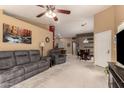 Open living room with soft carpet, ceiling fan, comfortable seating, and adjacent dining area at 20609 N 103Rd Dr, Peoria, AZ 85382
