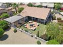 Aerial view of an outdoor patio with a firepit, seating, hammock, well-manicured lawn, and lush desert landscaping at 3021 N 148Th Dr, Goodyear, AZ 85395