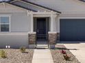 Close-up of a gated entrance with stone accents and a well-maintained walkway at 37111 W Parador Ln, Maricopa, AZ 85138