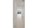 Bright hallway with tile flooring leads to open living space and features recessed lighting at 37151 W Parador Ln, Maricopa, AZ 85138