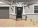 Welcoming front entrance featuring brick pillars, a secure metal gate, and a neatly paved walkway at 4032 S 176Th Dr, Goodyear, AZ 85338