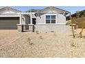Well-maintained front yard with decorative rock landscaping and a young tree, offering curb appeal at 4032 S 176Th Dr, Goodyear, AZ 85338