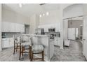 Bright kitchen boasts white cabinetry, stainless appliances, and a breakfast bar with stylish seating at 10123 E Pampa Ave, Mesa, AZ 85212