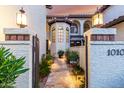 Inviting entrance with desert landscaping, walkway, gate and updated lighting in this home at 11011 N 92Nd St # 1010, Scottsdale, AZ 85260