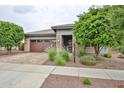 Charming single-story home with brick accents, a paver driveway, and well-maintained landscaping at 16140 W Sierra St, Surprise, AZ 85379