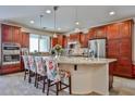 Spacious kitchen with stainless appliances, an island with bar seating, and ample dark wood cabinetry at 16140 W Sierra St, Surprise, AZ 85379