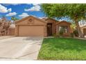 Inviting single-story home with a well-manicured lawn and a spacious driveway leading to the garage at 1905 E Palomino Dr, Gilbert, AZ 85296