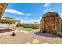 Spacious backyard featuring turf area, shed, block fence, and covered patio at 19661 N Central Ave, Phoenix, AZ 85024