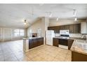 Open-concept kitchen featuring granite countertops, white appliances, track lighting, and adjacent living area at 19661 N Central Ave, Phoenix, AZ 85024
