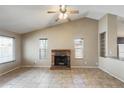 Open living area with vaulted ceiling, brick fireplace, ceiling fan, and tiled flooring throughout at 19661 N Central Ave, Phoenix, AZ 85024