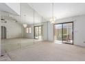 Bright and airy living room with large mirrored wall, sliding glass doors, and neutral carpet at 2039 W Ronald Rd, Phoenix, AZ 85029