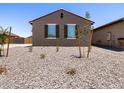 A cozy single-story home featuring minimal desert landscaping, a brown exterior, and shuttered windows at 322 S San Christo Ln, Casa Grande, AZ 85194