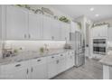 Bright kitchen with white cabinets, stainless steel appliances, and elegant granite countertops at 3466 E Hazeltine Way, Queen Creek, AZ 85142