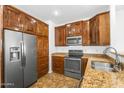 Well-lit kitchen features stainless steel appliances, granite counters, and custom wood cabinetry at 6710 E University Dr # 133, Mesa, AZ 85205