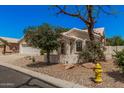 Cozy single-story residence featuring desert landscaping with mature tree and a yellow fire hydrant at 15460 W Amelia Dr, Goodyear, AZ 85395