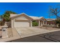 Inviting one-story home with a tile roof, two-car garage, and desert-style front yard at 15460 W Amelia Dr, Goodyear, AZ 85395