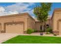 Charming home featuring a well-maintained lawn, desert landscaping, and an attached garage at 19812 N 90Th Dr, Peoria, AZ 85382