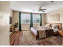 Cozy bedroom featuring hardwood floors, a ceiling fan, and large windows with stylish shutters at 3054 W Eagle Claw Dr, Phoenix, AZ 85086