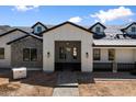 Inviting front entry with a covered porch, brick pavers, and stylish exterior lighting at 3323 N 81St St, Mesa, AZ 85207