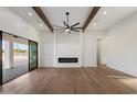 Spacious living room with an electric fireplace, wooden beams, and access to the backyard at 3323 N 81St St, Mesa, AZ 85207