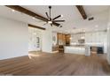 Open concept living and kitchen with wooden beams, light hardwood floors, and large island at 3323 N 81St St, Mesa, AZ 85207