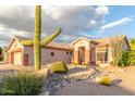 Charming single-story home with desert landscaping, featuring a large saguaro cactus and stone accents at 5381 S Emerald Desert Dr, Gold Canyon, AZ 85118