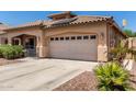 Attractive single-story house showcasing a tile roof and a spacious two-car garage with desert landscaping at 12238 W Monroe St, Avondale, AZ 85323