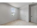 Bright bedroom features neutral carpeting, a large window, and a closet with sliding doors at 13503 W Calle De Baca --, Peoria, AZ 85383