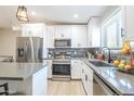Modern kitchen featuring stainless steel appliances, white cabinets, and a stylish backsplash at 4530 W Paradise Dr, Glendale, AZ 85304